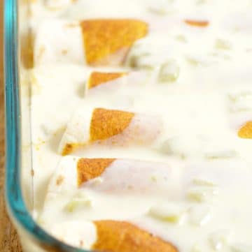 Green Chile Chicken Enchiladas with White Sauce Recipe - these cheesy chicken enchiladas with green chiles and white cheese sauce are a quick and easy dinner recipe idea perfect for the whole family. Our family loves these, and it's a great freezer meal too!