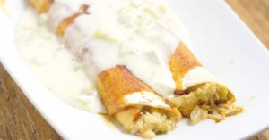 Green Chile Chicken Enchiladas with White Sauce Recipe - these cheesy chicken enchiladas with green chiles and white cheese sauce are a quick and easy dinner recipe idea perfect for the whole family. Our family loves these, and it's a great freezer meal too!