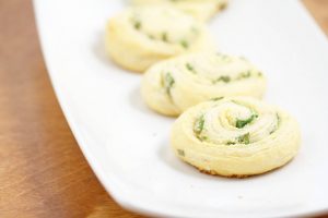 Parmesan Scallion Pinwheels Recipe- An easy, quick, and delicious appetizer recipe idea. Great for a party, Christmas, or a crowd. The buttery goodness of crescent rolls with Parmesan cheese and scallions for a pop of flavor.