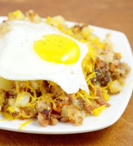 Farmer's Breakfast Skillet Recipe - an easy, hearty breakfast recipe idea with potatoes, ham, bacon, and veggies, topped with cheese and eggs. We love this recipe for brinner too!