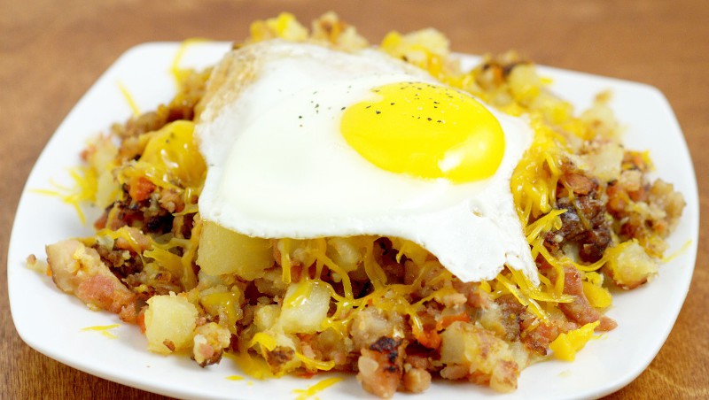 Farmer's Breakfast Skillet Recipe - an easy, hearty breakfast recipe idea with potatoes, ham, bacon, and veggies, topped with cheese and eggs. We love this recipe for brinner too!