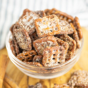 Cinnamon Sugar Pretzels in a small glass bowl on a wooden cutting board with a linen napkin behind.