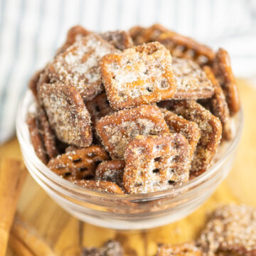 Cinnamon Sugar Pretzels in a small glass bowl on a wooden cutting board with a linen napkin behind.