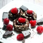 Raspberry Ganache Thumbprints Cookie Recipe - a pretty but easy dessert cookie recipe.  Chocolate thumbprints filled with a rich super easy chocolate raspberry ganache and topped with a fresh raspberry.  Makes a pretty Christmas cookie too!