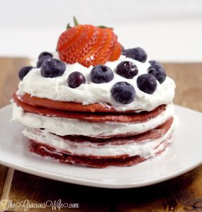 Red Velvet Pancakes Recipe with fresh berries - a delicious breakfast recipe with red velvet pancakes, whipped cream, and fresh berries. The patriotic red white and blue are super cute for a 4th of July breakfast food idea too!