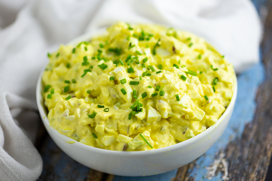 Classic Egg Salad in a white bowl topped with fresh chives