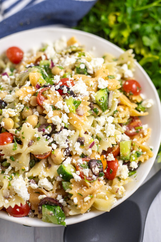 Overhead view of easy feta pasta salad with fresh cherry tomatoes, cucumbers, chickpeas, and lots of feta tossed with a tangy vinaigrette.
