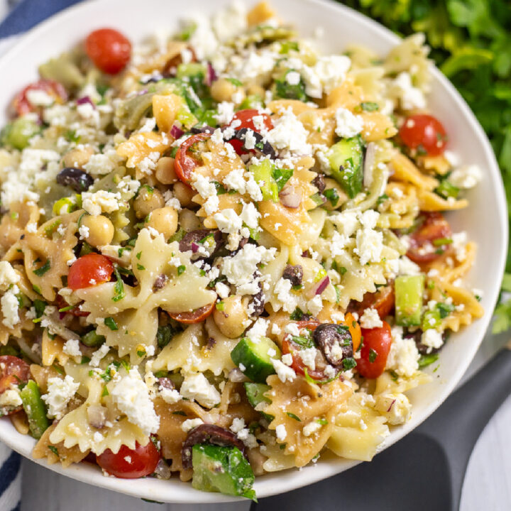 Overhead view of easy feta pasta salad with fresh cherry tomatoes, cucumbers, chickpeas, and lots of feta tossed with a tangy vinaigrette.