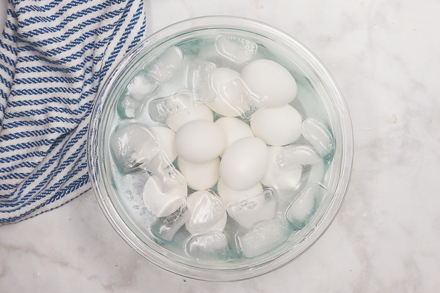 Hard boiled eggs in a glass bowl full of ice water