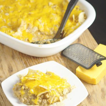 This Taco Bake Casserole recipe makes family taco night even more delicious with gooey cheese, crunchy tortilla chips, and perfectly seasoned taco meat. Quick and easy dinner recipe idea that the whole family will love! My husband used to eat this when he was a kid! So yummy!