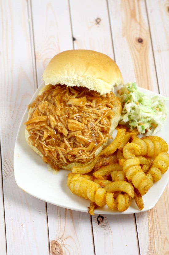 Ridiculously easy Crockpot Barbecue Chicken Sandwiches recipe with just 3 ingredients! Sweet and spicy barbecue with the tang of apple cider vinegar, all in one sandwich in the slow cooker. Top with creamy coleslaw for an extra bit of sweet crunch. Perfect for an easy family dinner idea!