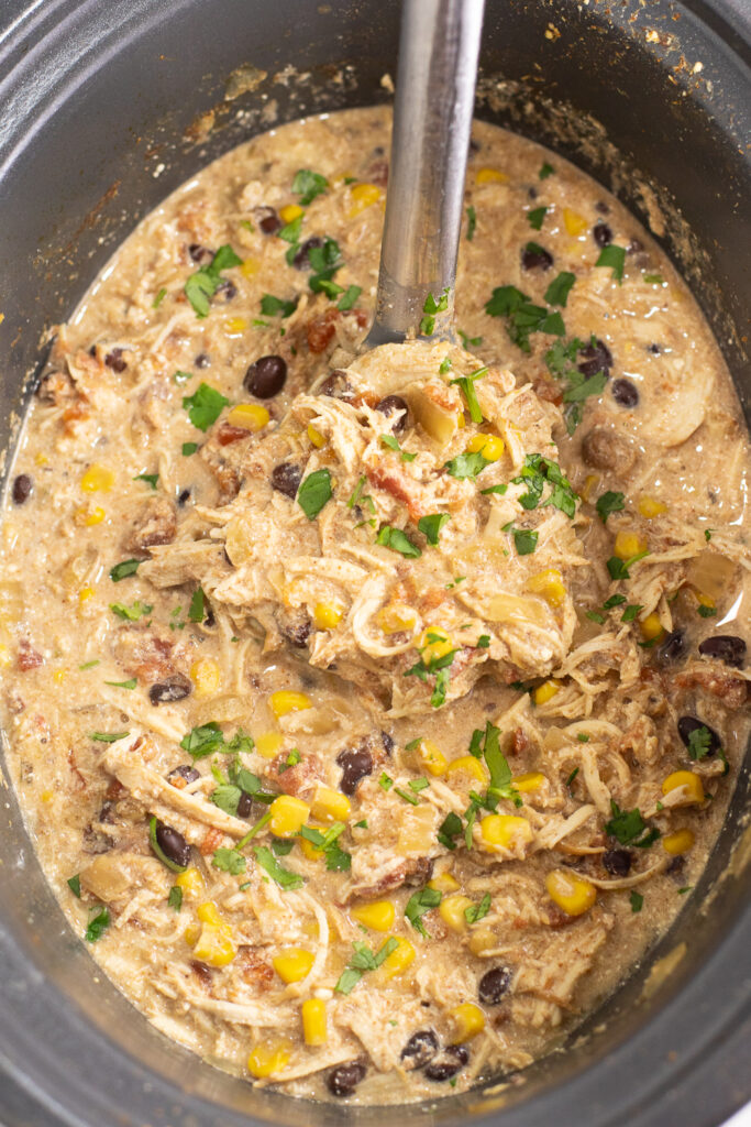 Crockpot southwest chicken chili in a slow cooker with a ladle in it.
