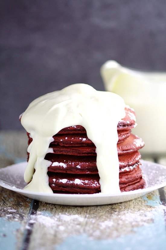 Red Velvet Pancakes with Cream Cheese Glaze make a delicious and decadent Valentine's Day breakfast recipe.  Red Velvet Pancakes made from a box cake mix topped with a creamy, simple cream cheese glaze. Couldn't be a more delicious way to start the day! 
