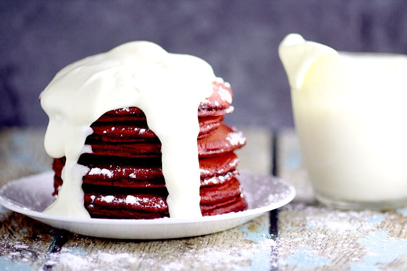Red Velvet Pancakes with Cream Cheese Glaze make a delicious and decadent Valentine's Day breakfast recipe.  Red Velvet Pancakes made from a box cake mix topped with a creamy, simple cream cheese glaze. Couldn't be a more delicious way to start the day! 