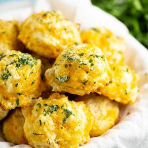 Cheddar Bay Biscuits in a white linen with parsley in the background