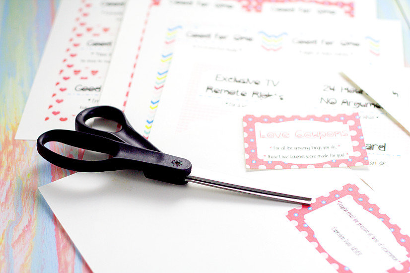 Black scissors on top of printed love coupon book