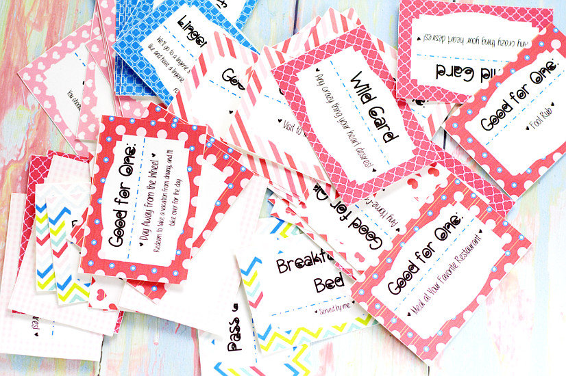 Cut out love coupons in a pile on a pastel rainbow wood background