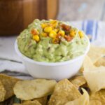 Creamy Corn Guacamole is the the perfect easy appetizer dip recipe for your next party.  Chunky and delicious Creamy Corn Guacamole with charred corn, tomatoes, onions, and creamy avocados.  Plus a special, easy ingredient to bring this amazing dip to the next creamy level. Must try!