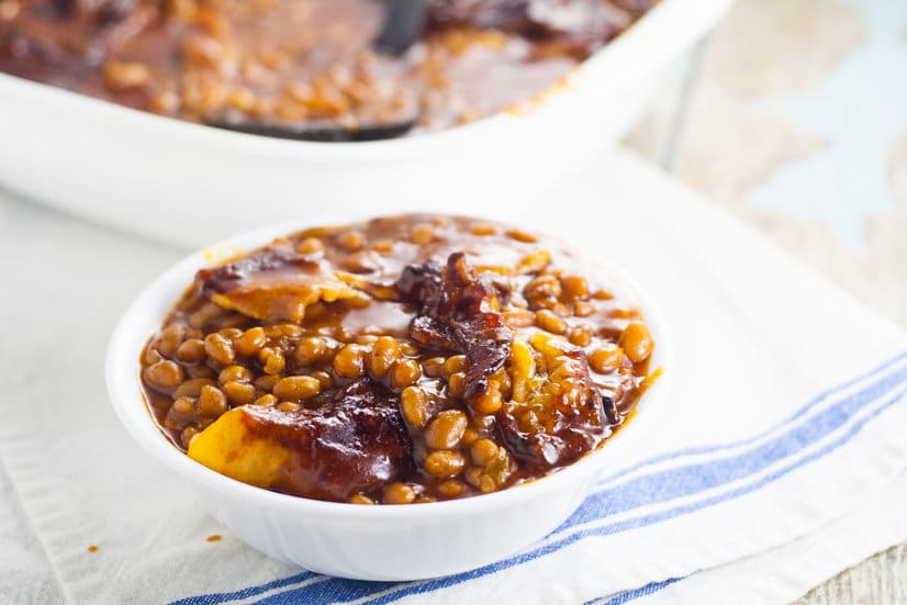 Homemade Bacon Baked Baked Beans are easier to make than you think! Sweet and tangy Homemade Bacon Baked Beans, slow baked with bacon are the perfect summer side dish for your next barbecue or cookout! Yum!