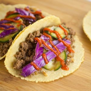 Asian Beef Tacos recipe with cucumber slaw - An Asian kick on your old family dinner favorite, these Asian Beef Tacos topped with cool sour cream, crisp cucumber slaw, and spicy Sriracha make taco night even more spectacular.  Wow, the slaw on these tacos really makes it amazing!