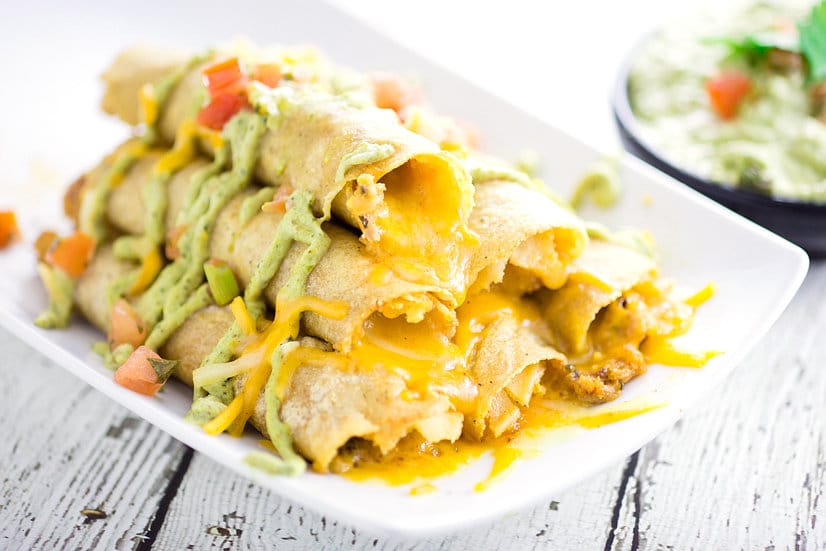 Cheesy Baked Chicken Taquitos recipe - Easy and cheesy Baked Chicken Taquitos will become a yummy, Mexican-inspired family dinner favorite in no time! Serve with the Roasted Creamy Poblano Dip for an extra zesty and a little spicy kick. These look amazing! So cheesy!