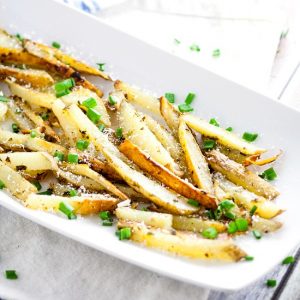 Garlic Chive Baked French Fries recipe - This Garlic Chive Baked French Fries recipe turns an American classic into a zesty new favorite with fresh garlic and chives tossed with butter and fries and baked in the oven. This looks like a fabulous quick and easy side dish recipe!  What's not to love?!