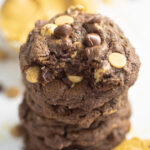 Stacked peanut butter chip chocolate cookies with a bite taken out of the top one.