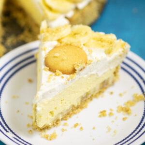 No Bake Banana Cream Cheesecake topped with a vanilla wafer on a small white plate.