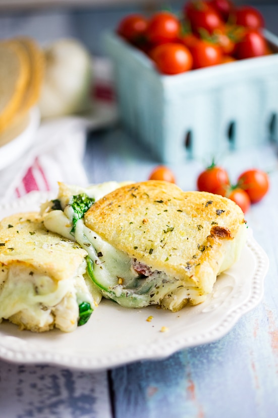 Oven Baked 5 Cheese White Pizza Grilled Cheese Recipe - Baked in the oven to golden, gooey perfection, this deluxe 5 Cheese White Pizza Grilled Cheese is the ultimate cheesy sandwich with 5 types of real cheese, a garlic herb ricotta spread, garlic butter, tangy cherry tomatoes and spinach. 