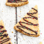 Chocolate Drizzled Shortbread Recipe - A classic buttery shortbread recipe cut into triangles and drizzled with chocolate and festive sprinkles makes this fun Chocolate Drizzled Shortbread cookies look like little Christmas trees.