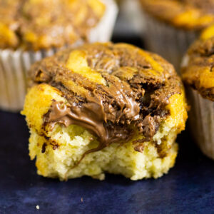 Nutella Banana Muffin with a bite taken out with more muffins behind.