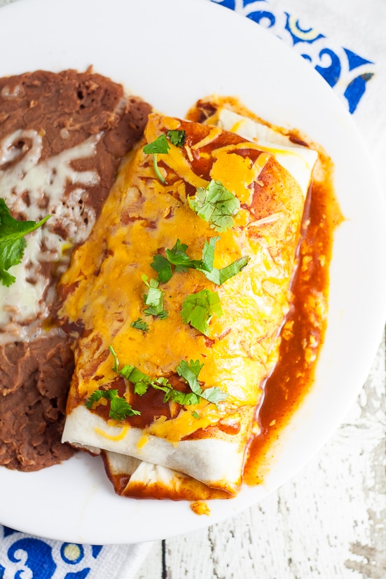 Rice and Black Bean Burritos Recipe - Quick and easy Mexican-inspired dinner recipe, these Rice and Black Bean Burritos are filled with flavorful rice and beans and smothered in enchilada sauce and cheese for a yummy vegetarian dinner perfect for Meatless Monday.