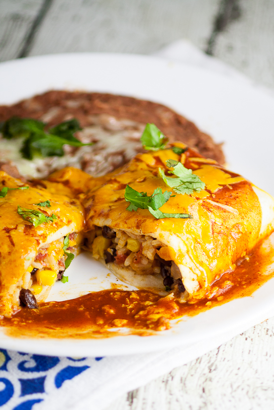 Rice and Black Bean Burritos Recipe - Quick and easy Mexican-inspired dinner recipe, these Rice and Black Bean Burritos are filled with flavorful rice and beans and smothered in enchilada sauce and cheese for a yummy vegetarian dinner perfect for Meatless Monday.