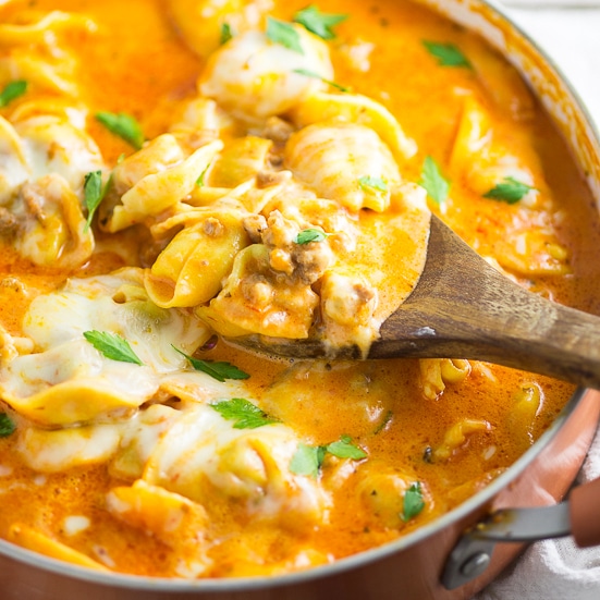Italian sausage and tortellini nestled in a creamy tomato sauce and topped with gooey mozzarella cheese in this Creamy Sausage and Tortellini make a quick and easy pasta dinner that the whole family will love! A delicious one pan meal that combines the tender, cheese filled pasta with savory sausage and wraps it all in a creamy cheesy tomato sauce. One bite and you'll wonder where it's been all your life!