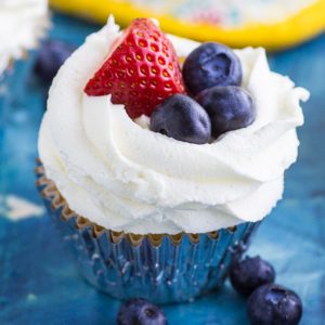 These Berries and Cream Cupcakes are made with a moist vanilla cupcake with strawberries and blueberries mixed in, filled with strawberry preserves, and topped with whipped cream cheese frosting and more fresh berries for a cupcake that is not only delicious, but perfect for summer! 