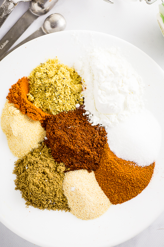 Spices to make homemade fajita seasoning on a white plate