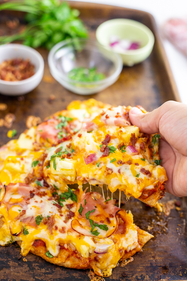 This Flatbread Hawaiian Pizza is quick, easy, and totally delicious! An addicting tangy, salty sweet combination with ham, pineapple, cheese, and a little bacon for good measure. 