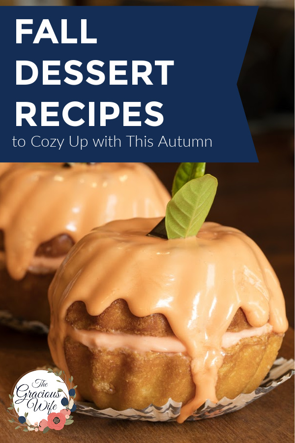 Two mini bundt cakes stacked on each other to look like a pumpkin with orange glaze running down and a mint leaf on top. The words "Fall Dessert Recipes to Cozy Up with This Autumn" are overlayed.