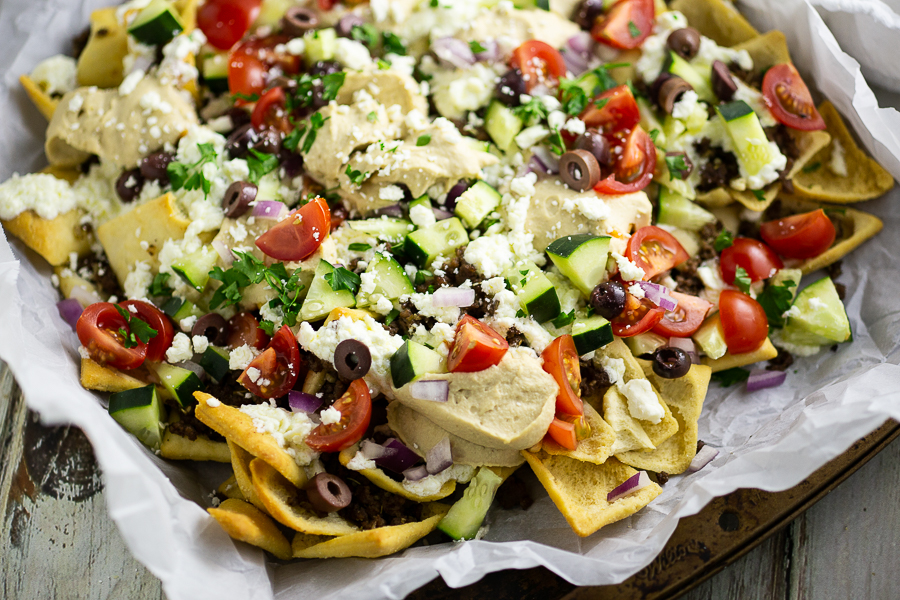 Greek Nachos on parchment paper on an old baking sheet