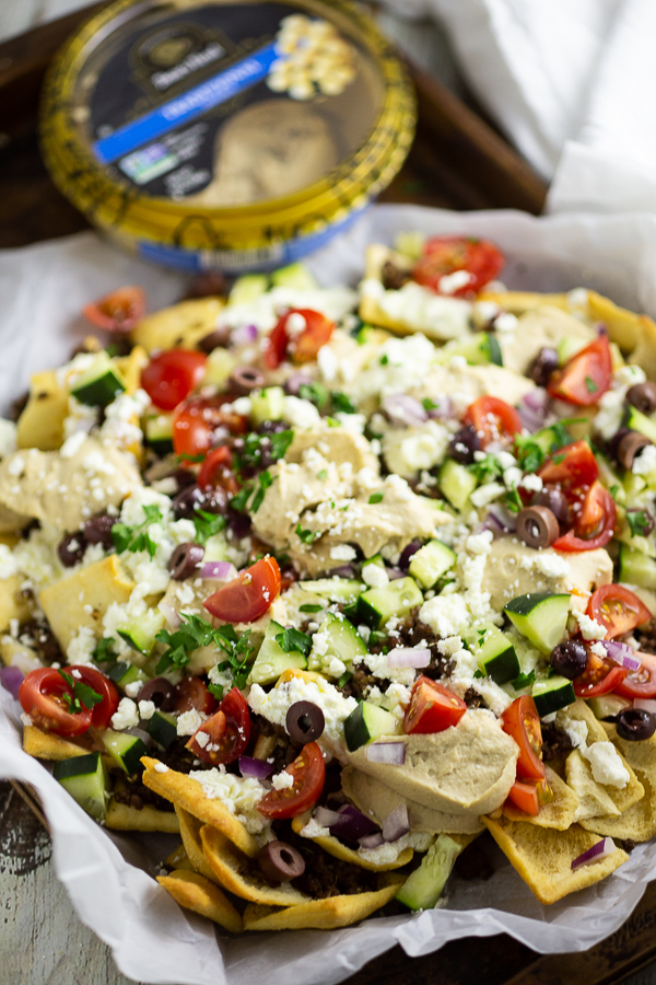 Greek Nachos on parchment paper on an old baking sheet