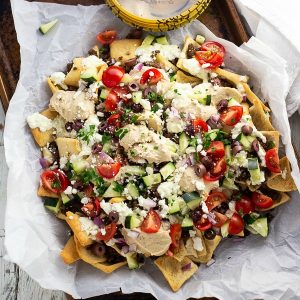 Greek Nachos on parchment paper on an old baking sheet