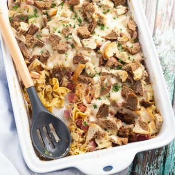 Reuben Casserole is a family favorite with layers of warm egg noodles, tangy sauerkraut, thousand island dressing, corned beef, gooey cheese, and buttery toasted rye bread. It's like a reuben sandwich made even better in one dish for easy clean up! #easyrecipe #stpatricksday