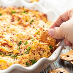 Make this easy Irish-inspired Reuben Dip recipe with creamy Thousand Island, tangy sauerkraut, salty corned beef, and gooey cheese in less than 30 minutes with just 5 ingredients! Great festive appetizer recipe for St Patrick's Day.