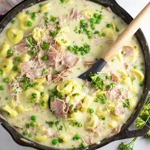 Make this quick and easy Creamy Ham and Pea Tortellini in one pot in just 30 minutes with salty ham, sweet peas, and gooey cheese for a perfect easy weeknight pasta dish the whole family will love!