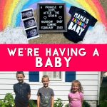 Rainbow drawn in chalk on a sidewalk with an ultrasound, a sign, and a onesie