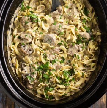 Slow Cooker Beef Stroganoff is so easy to make in the crockpot with tender beef and fresh mushrooms in a creamy herb sauce, served over warm egg noodles for a perfect comfort food family meal. A traditional recipe from scratch with sour cream that is truly the best you'll ever have!