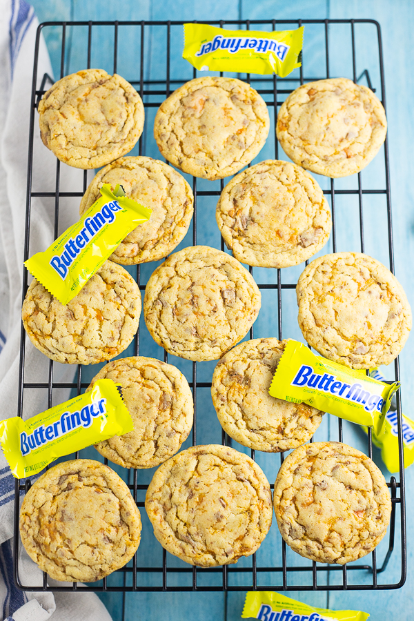 Butterfinger Cookies on a cooling rack with mini Butterfingers with an aqua wood background
