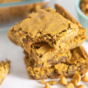 Stack of 4 butterscotch blondies with a bite taken out of the top one