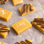 Microwave caramels cut into rectangles and scattered on wax paper. Some are drizzled in chocolate and some are sprinkled with sea salt.