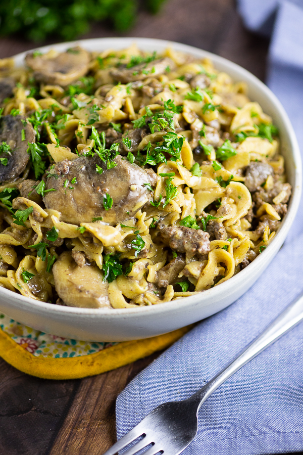 Ground Beef Stroganoff in a white bowl on a blue canvas linen